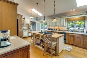 A kitchen with wooden cabinets, a central island, pendant lighting, and a view of the outdoors. - Mtn-view Hilltop Home, 5 Mi to Hendersonville (Hendersonville)