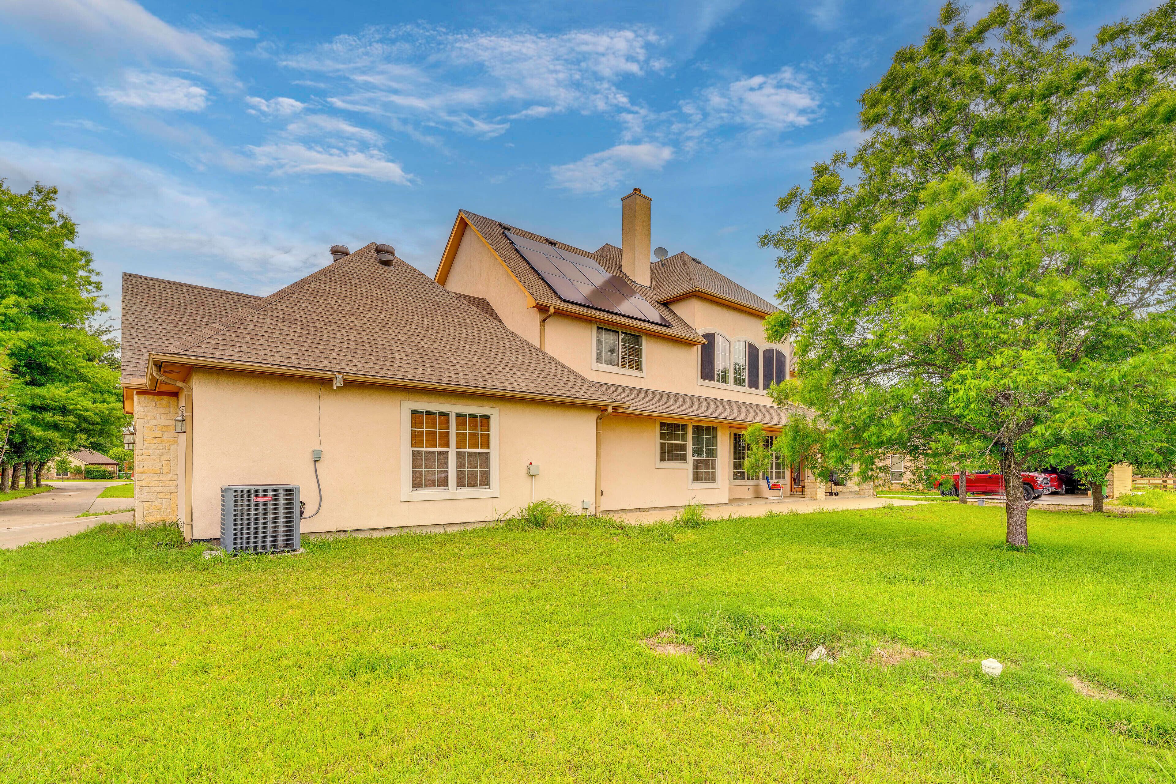 A two-story house with a sloped roof, a chimney, and a well-maintained lawn.