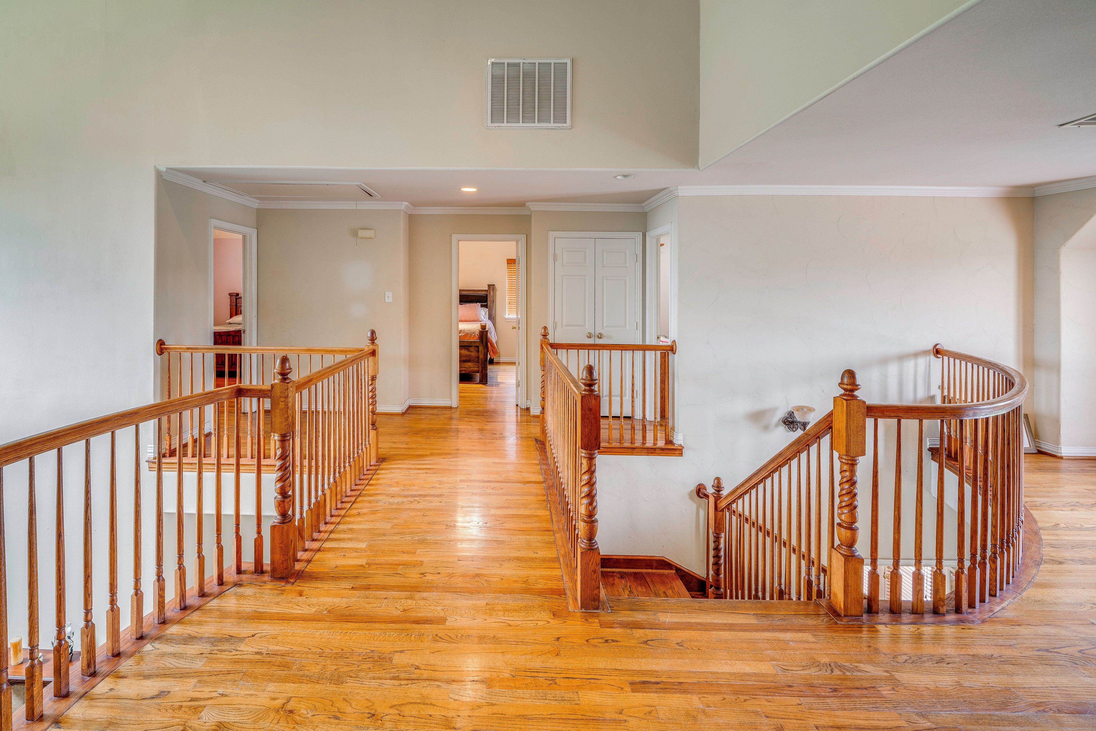 Un escalier en bois, doté d’une rampe, qui mène à l’étage supérieur.