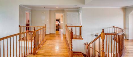 Un escalier en bois, doté d’une rampe, qui mène à l’étage supérieur.