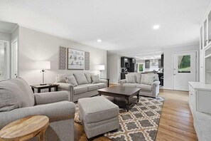 Ein modernes Wohnzimmer mit zwei Sofas, einem Couchtisch und einem Teppich.