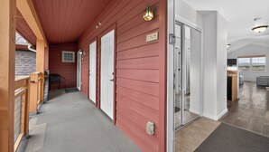 Ein Korridor mit roter Holzverkleidung, weißen Türen und einem Schild mit der Nummer D305.