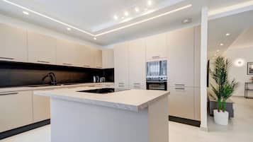 Una cocina moderna con una isla central, electrodomésticos integrados y un diseño minimalista.