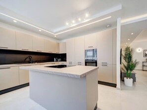 Eine moderne Küche mit Kochinsel, integrierten Geräten und minimalistischem Design.
