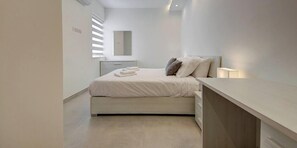 Ein modernes Schlafzimmer mit Bett, Nachttisch und Spiegel.