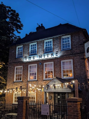 A brick building with 'THE MITRE' sign, multiple windows, and a signboard indicating 'Fine Ale & Food Accommodation Function Hire.' - Mitre (Knaresborough)