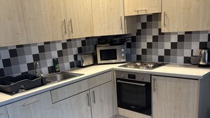 Eine moderne Küche mit Mikrowelle, Toaster, Wasserkocher und Backofen.