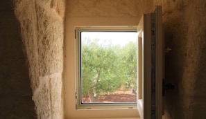 Ein Zimmer mit Fenster, einer HolztĂŒr und einer Wand mit strukturierter OberflĂ€che.