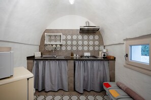 Eine kleine Küche mit eingebautem Herd, Spüle und Fenster.