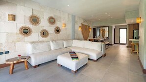 A spacious living area with a white sofa, a small wooden table, and a bench. - Private Pool on Luxury PentHouse (Playa del Carmen)