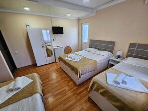 A hotel room with two beds, a desk, a chair, a TV, and a door. - hotel IMERI (Ureki)