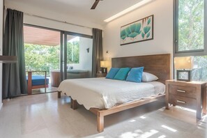 Une chambre à coucher avec un grand lit, une table de chevet, une fenêtre avec des rideaux et une vue sur la verdure.