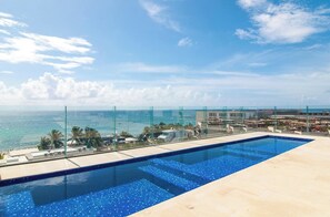 Ein Infinity-Pool auf dem Dach mit freiem Blick auf das Meer und die Stadt.