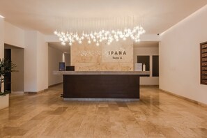 Ein Hotel-Empfangsbereich mit Marmor-Tresen, einer Kandelaber und einem Schild mit der Aufschrift 'IPANA Torre A'.