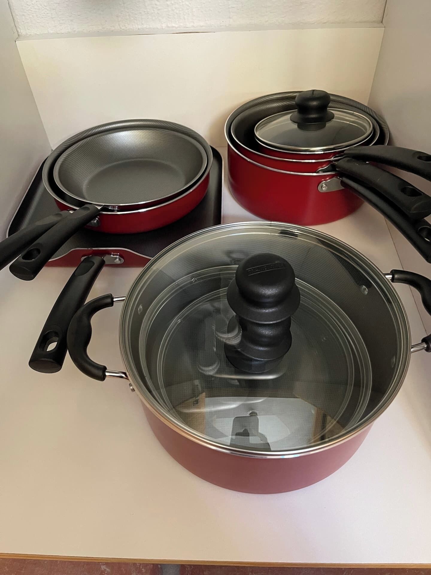 Una cocina con estufa, sartén y olla con tapa.