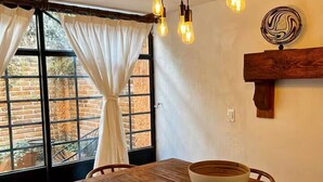 A wooden dining table with chairs, a bowl, and a hanging light fixture. - Comfort and Design near the Town - 3 Bedrooms (Mazamitla)