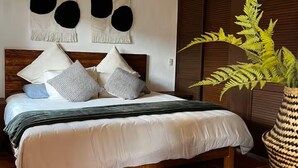 A bed with a wooden headboard, a bedside plant, and a wall-mounted light fixture. - Comfort and Design near the Town - 3 Bedrooms (Mazamitla)