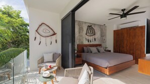 A modern bedroom with a large bed, a ceiling fan, and a view of greenery outside. - Ixchel Luxury PH Studio Priv Rooftop Pool 150 WiFi (Tulum)