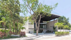 A modern building with a covered entrance, surrounded by trees and greenery. - Ixchel Luxury PH Studio Priv Rooftop Pool 150 WiFi (Tulum)