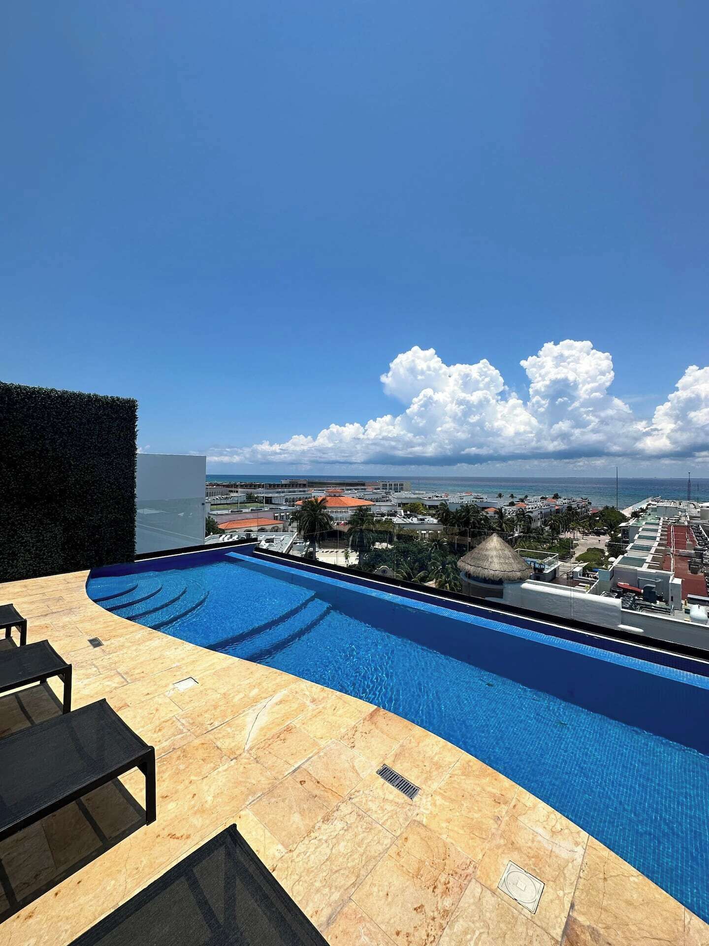 A swimming pool with a view of a cityscape and the ocean.