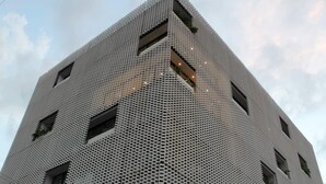 En høj bygning med et markant geometrisk mønster og mange vinduer.