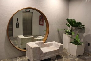 A bathroom with a large mirror, a marble sink, and potted plants. - Studio in Romantic Zone at Rincon de Almas (Puerto Vallarta)