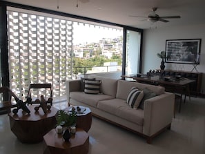 En moderne stue med sofa, sofabord og spiseplads.