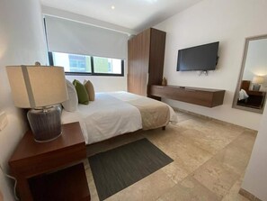 Ein modernes Schlafzimmer mit einem Bett, einem Fernseher, einem Spiegel und einem Holzschrank.