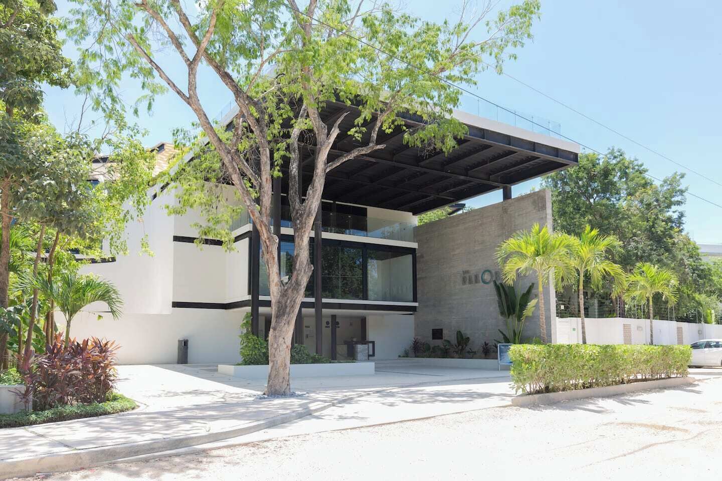 Un bâtiment moderne doté d’un toit plat, de grandes fenêtres et d’un espace d’entrée abrité.