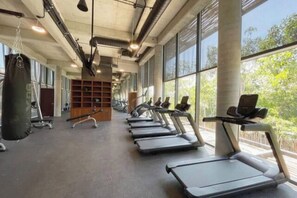 Ein Fitnessstudio mit Laufbändern, Kraftgeräten und einem Boxsack.