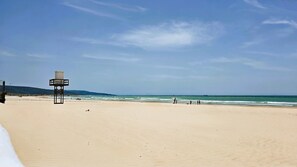 A beach with a lifeguard tower, sandy beach, and ocean view. - Central Duplex with Private Solarium in Barbate (Barbate)