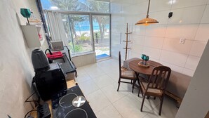 Eine Küche mit Essbereich, Blick auf den Strand und Deckenventilator.