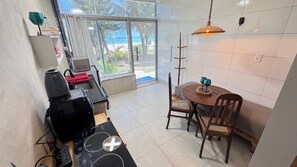 Eine Küche mit Essbereich, Blick auf den Strand und Deckenventilator.