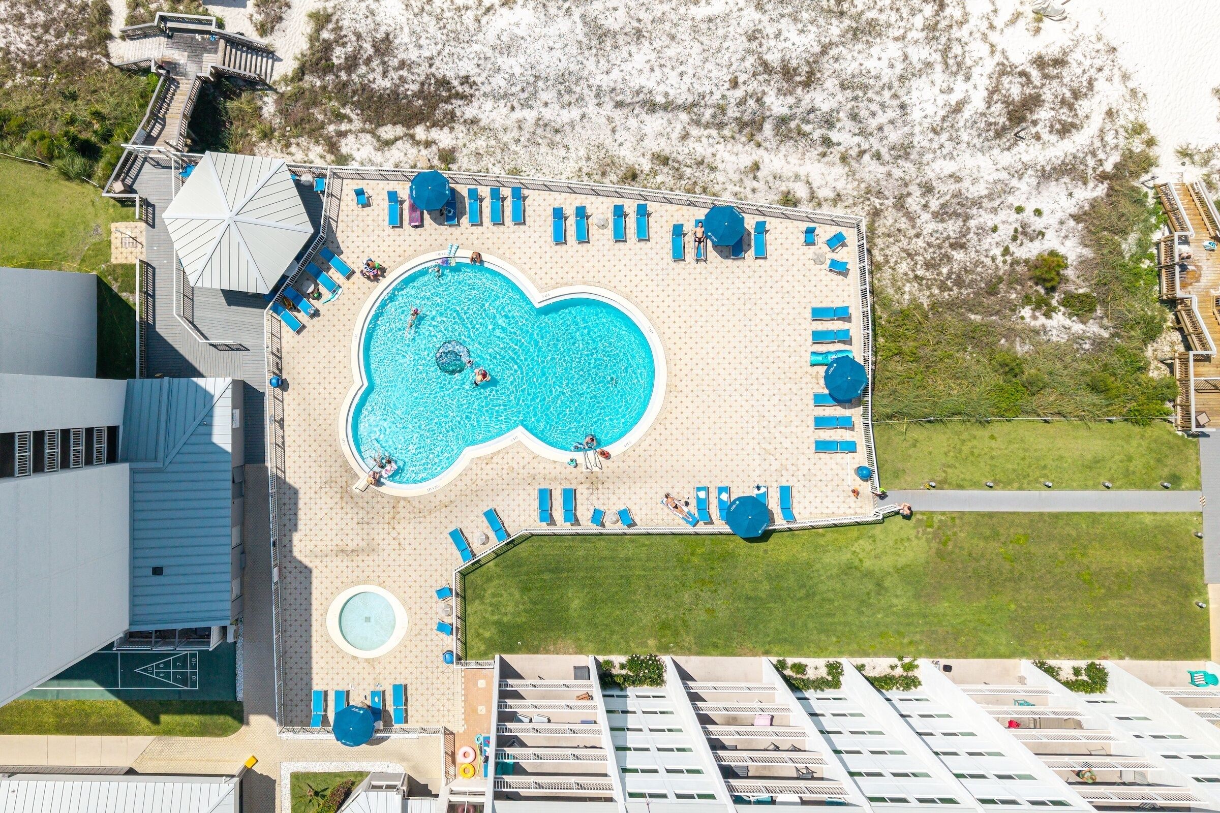 Une piscine sur le toit, dotée de plusieurs chaises longues et d’un jacuzzi circulaire.