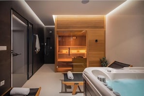 Ein modernes Badezimmer mit Dusche, Badewanne und Sauna.