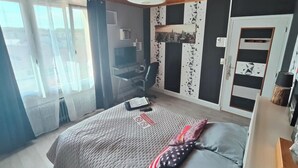 A bedroom with a bed, a desk, and a chair. - Bed and breakfast in the center of Migennes, near train station and amenities (Migennes)