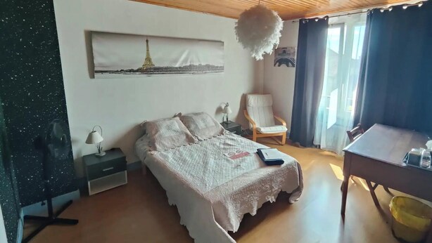 A bedroom with a bed, a chair, a desk, a lamp, and a ceiling fan. - Bed and breakfast in the center of Migennes, near train station and amenities (Migennes)
