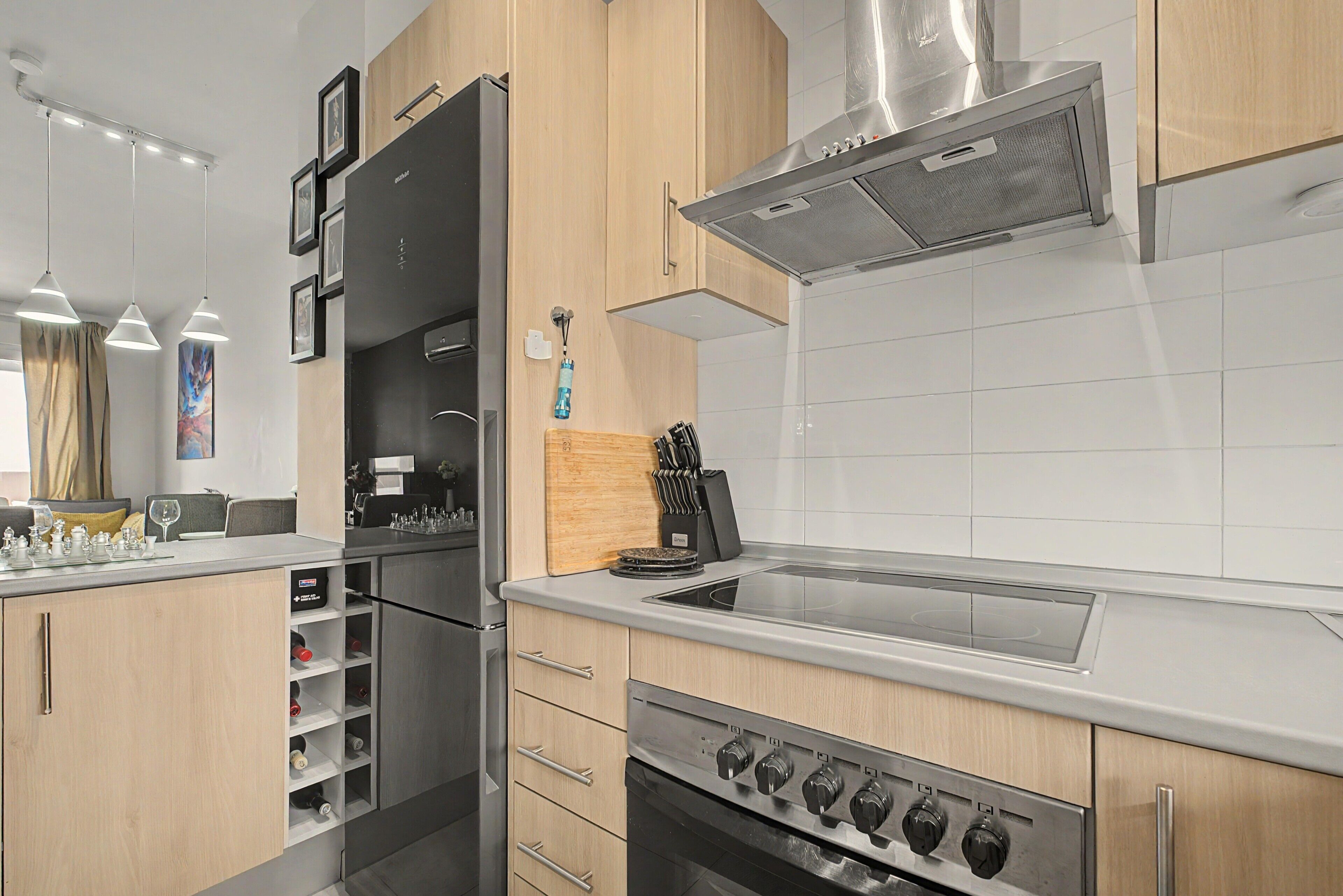 Una cocina moderna con horno empotrado, microondas y campana extractora de acero inoxidable.