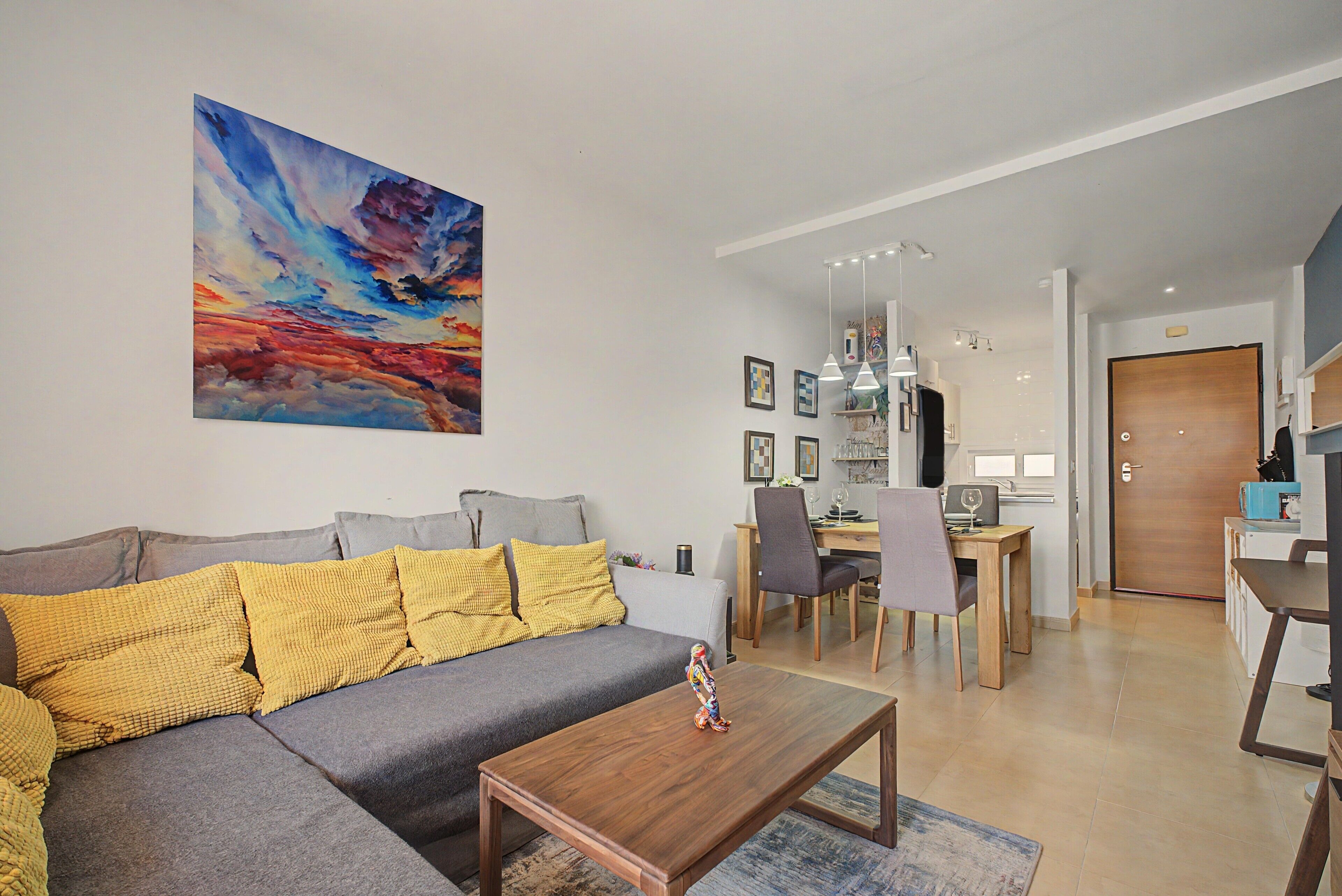 Una sala de estar moderna con un sofá, una mesa de centro y un cuadro en la pared.