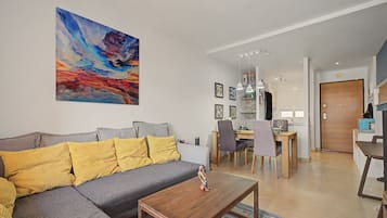 Una sala de estar moderna con un sofá, una mesa de centro y un cuadro en la pared.