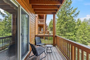 A wooden deck with a glass door, two chairs, and a small table. - Central Dillon Retreat | Ski, Hike, Explore (Dillon)