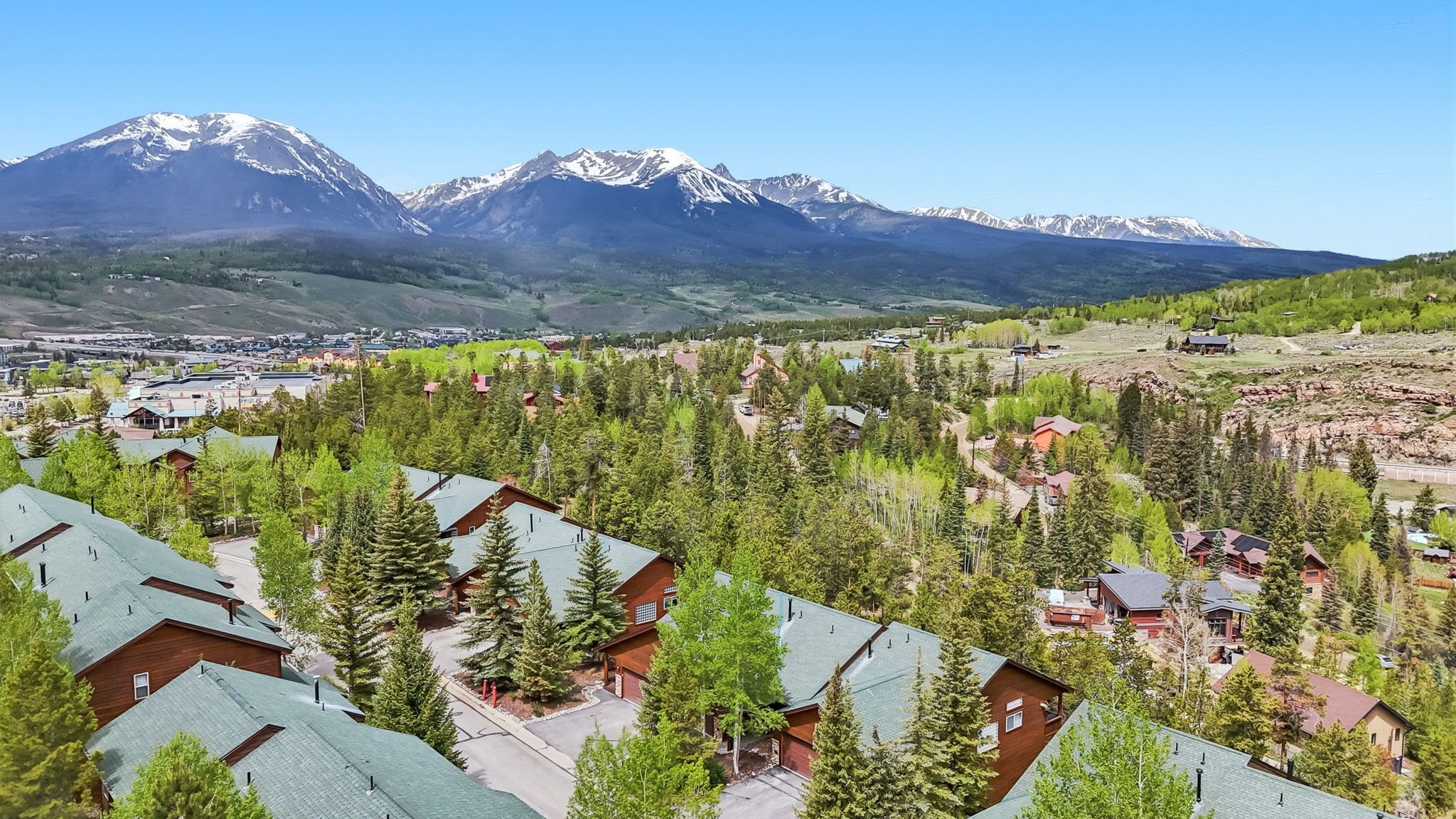 A residential area with houses, a road, and a mountain range in the background.