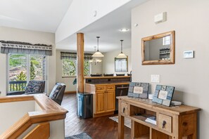A kitchen with wooden cabinets, a dining area with a bench, and a view of the outdoors. - Central Dillon Retreat | Ski, Hike, Explore (Dillon)