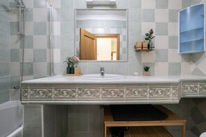 Ein Badezimmer mit Dusche, Waschbecken, Spiegel und Schrank.