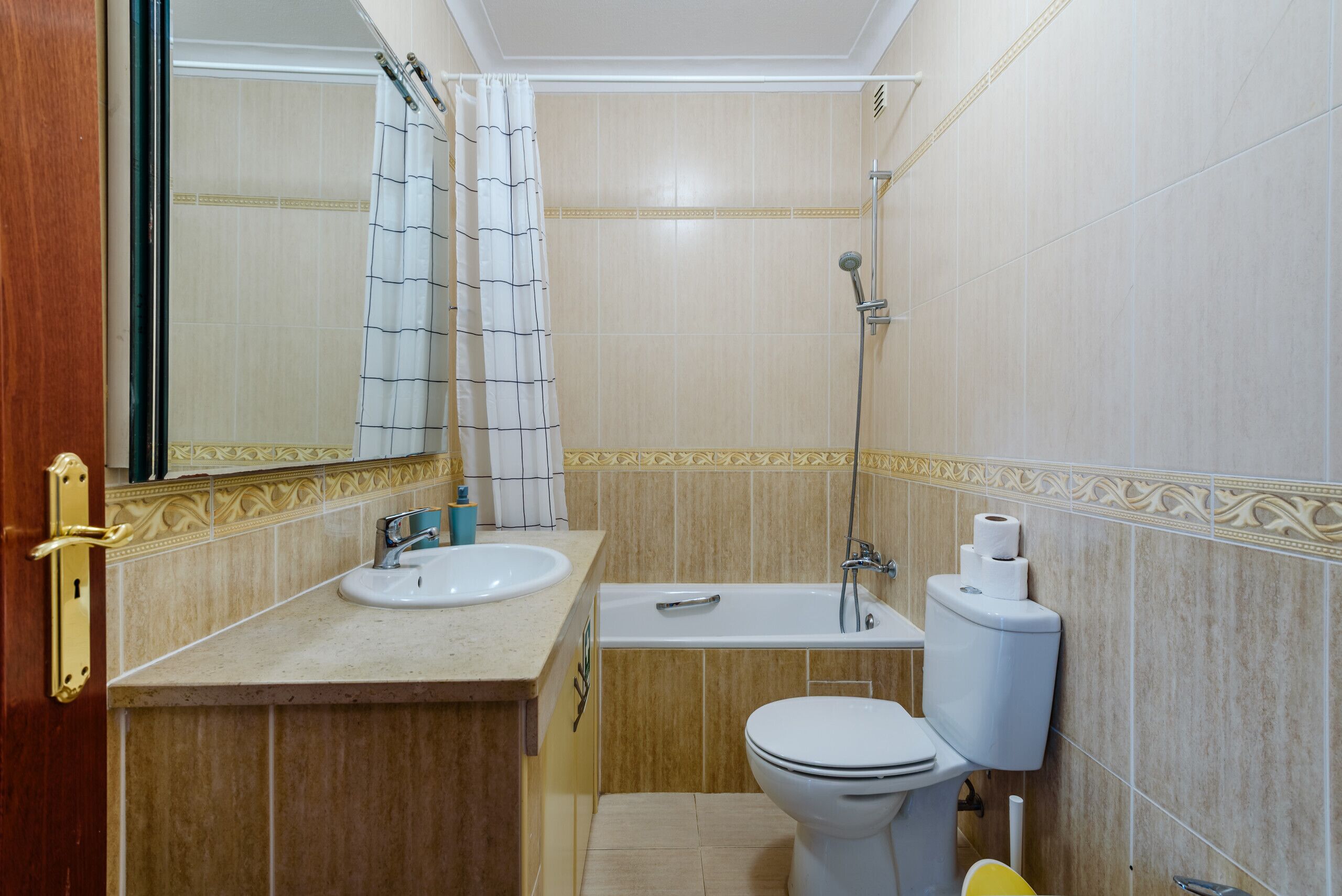 Een badkamer met een wastafel, toilet, bad en douche.