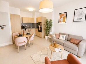 A modern apartment with a dining area, kitchen, and living room.