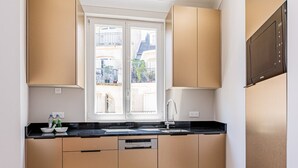 Una cucina moderna con un'ampia finestra, mobili in legno e forno incassato.