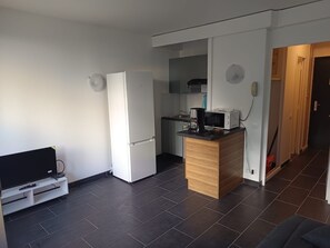 A compact living space with a kitchenette, a refrigerator, a microwave, a coffee maker, and a TV on a stand. - 4bedroom apartment in Antibes Juan les pins (Juan les pins)