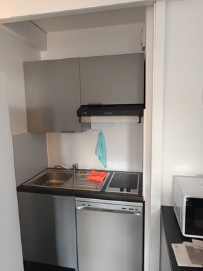 A compact kitchen with a stainless steel sink, a built-in oven, and a microwave. - 4bedroom apartment in Antibes Juan les pins (Juan les pins)