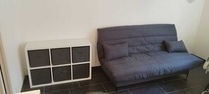 A room with a grey sofa, a white storage unit, and black tiled flooring. - 4bedroom apartment in Antibes Juan les pins (Juan les pins)